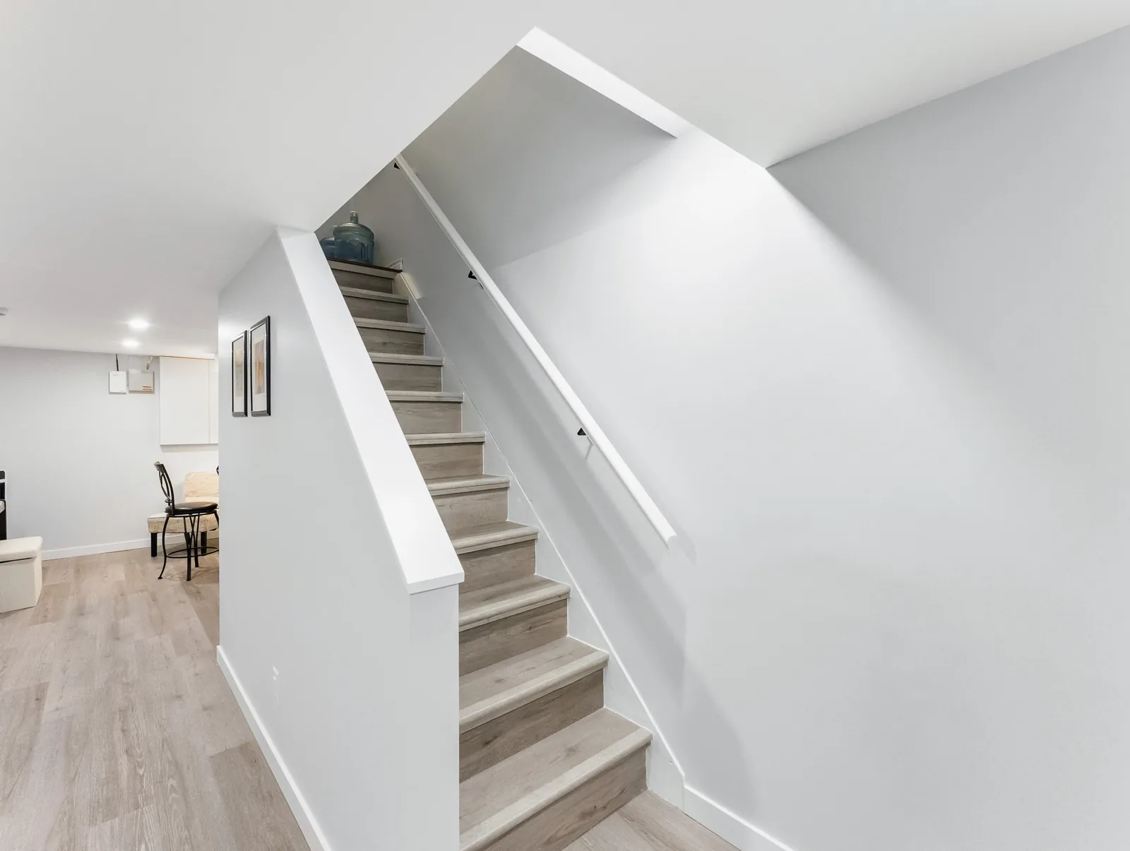 Rebuilt stair to the basement, wood treads against white risers and rail