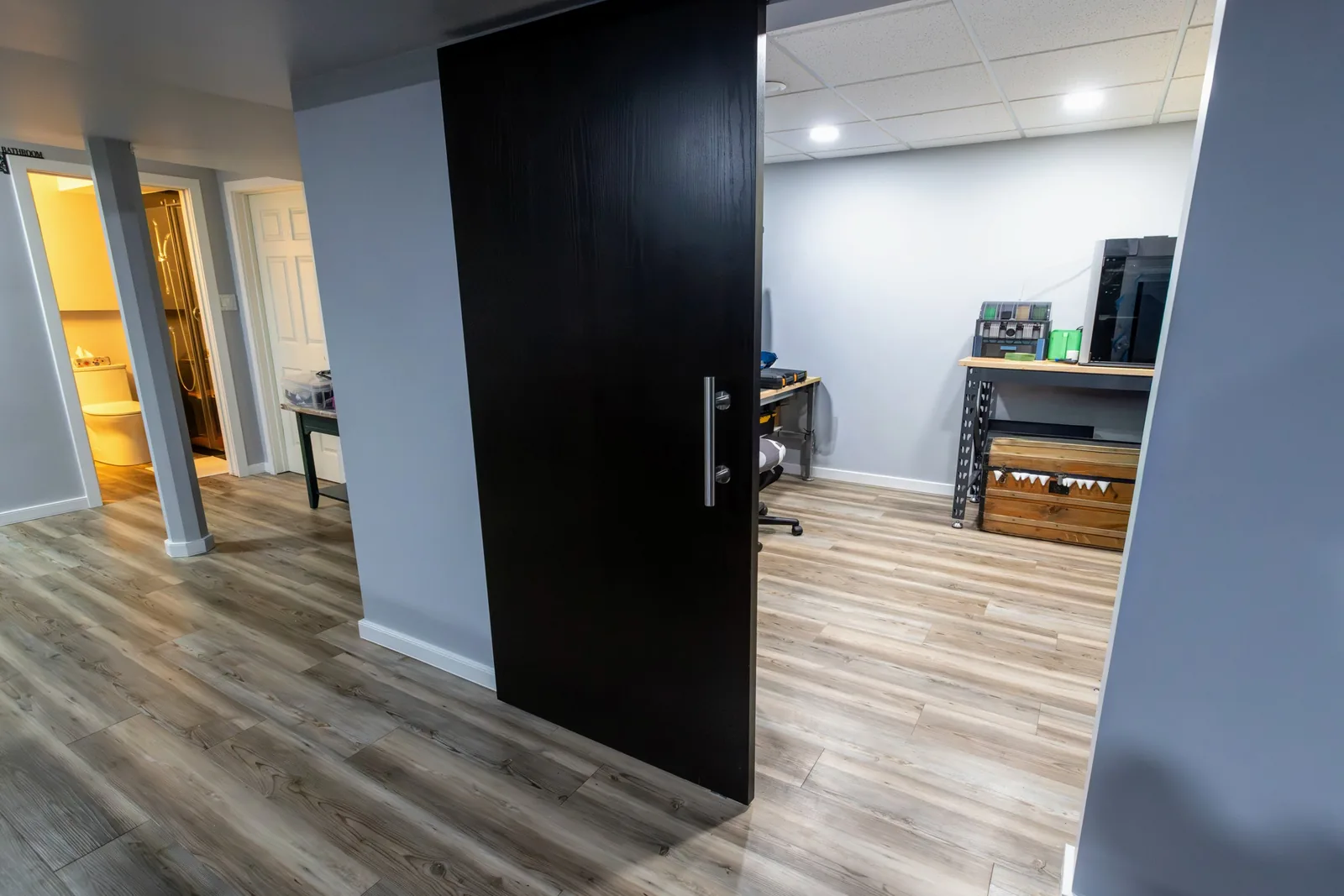 The finished lower level, black barn door on its track