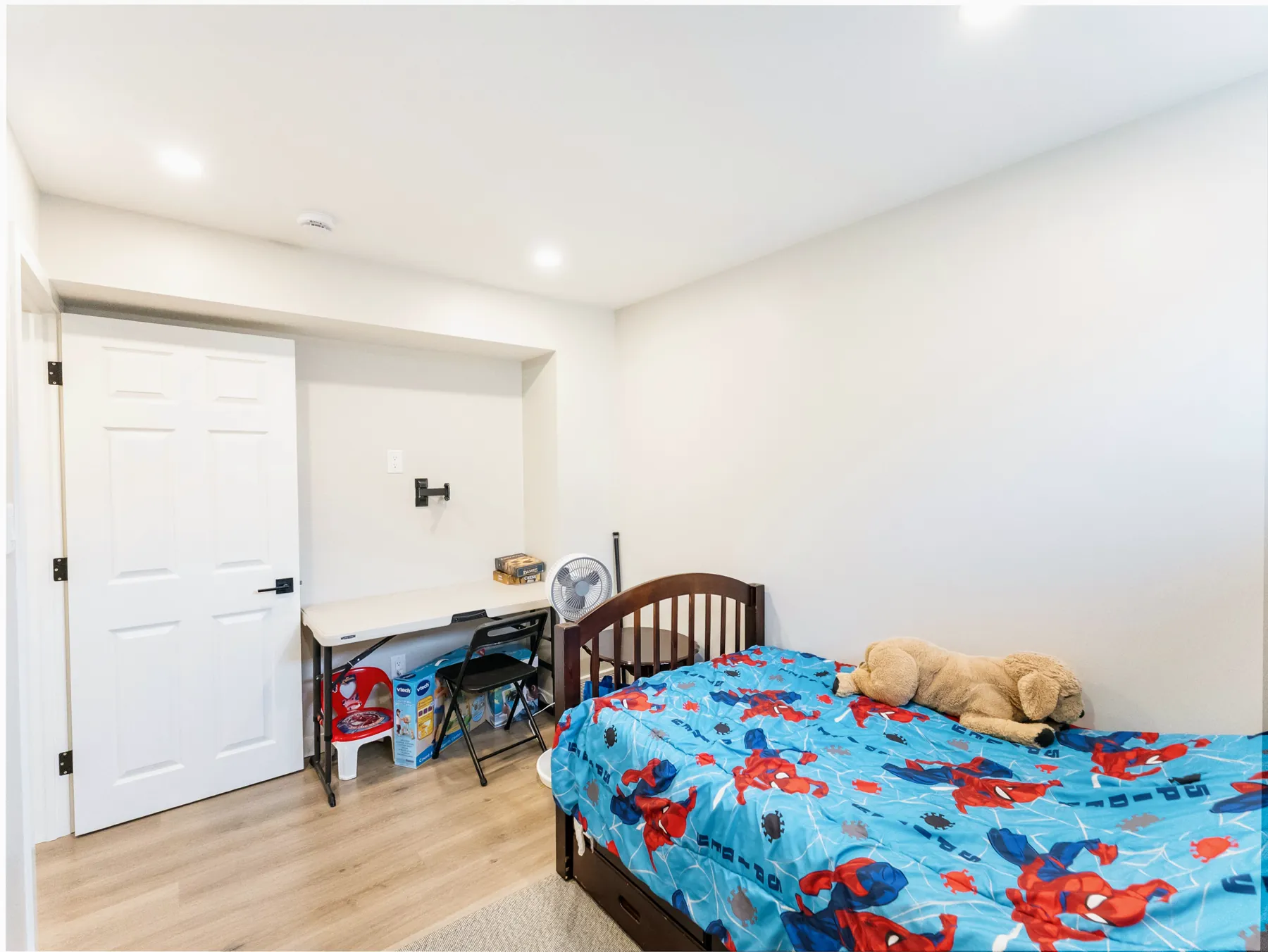 Basement bedroom with a carpeted floor and a door through to the hall
