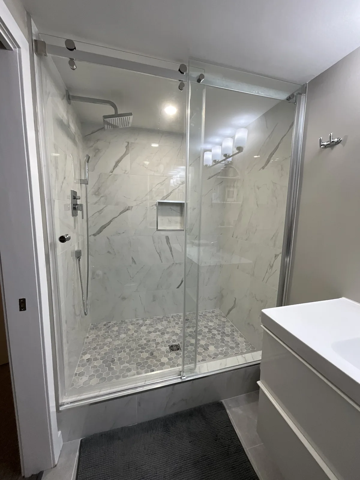The shower with its pebble floor and recessed niche