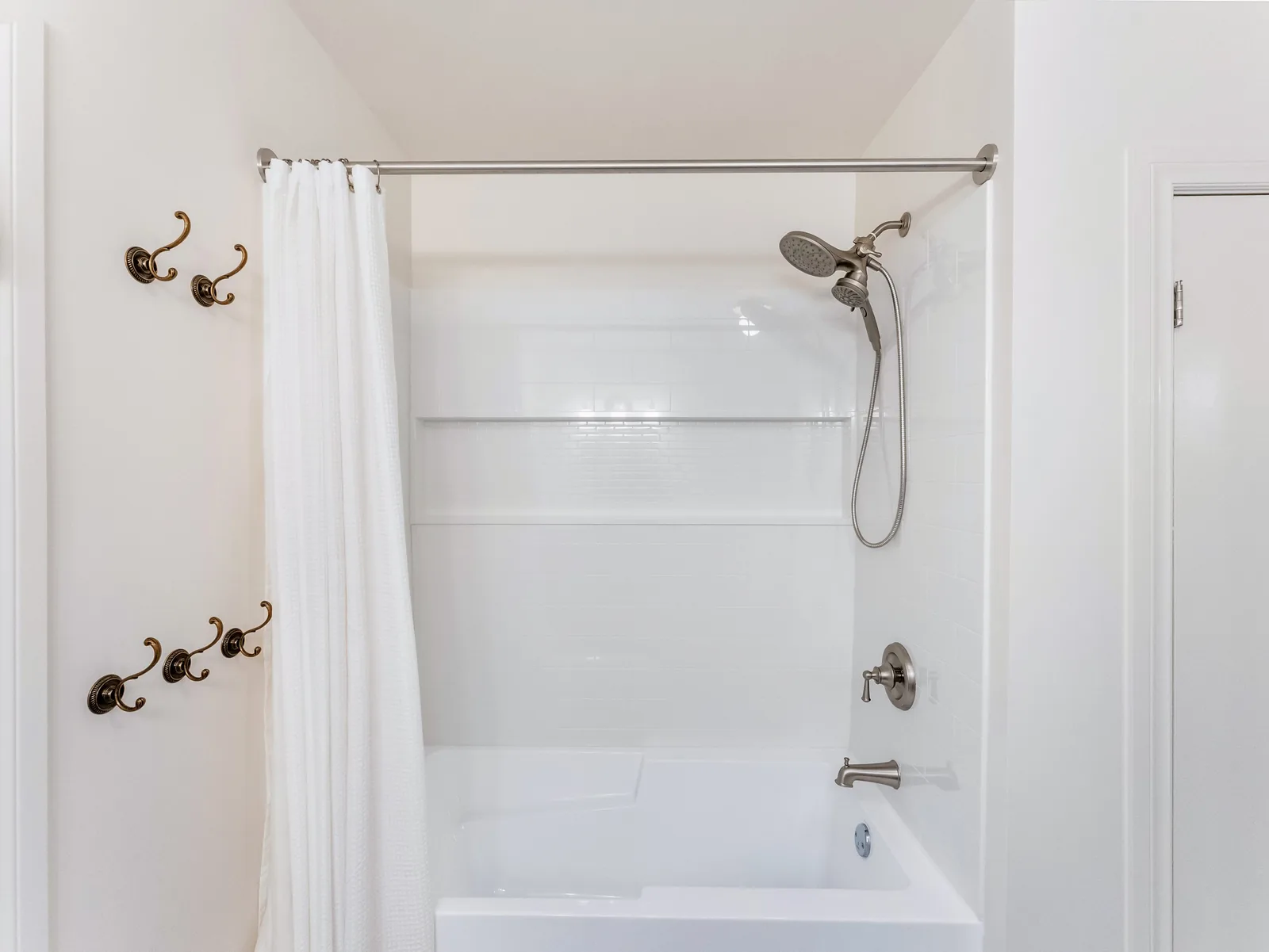 Hand shower and tub filler against the white surround