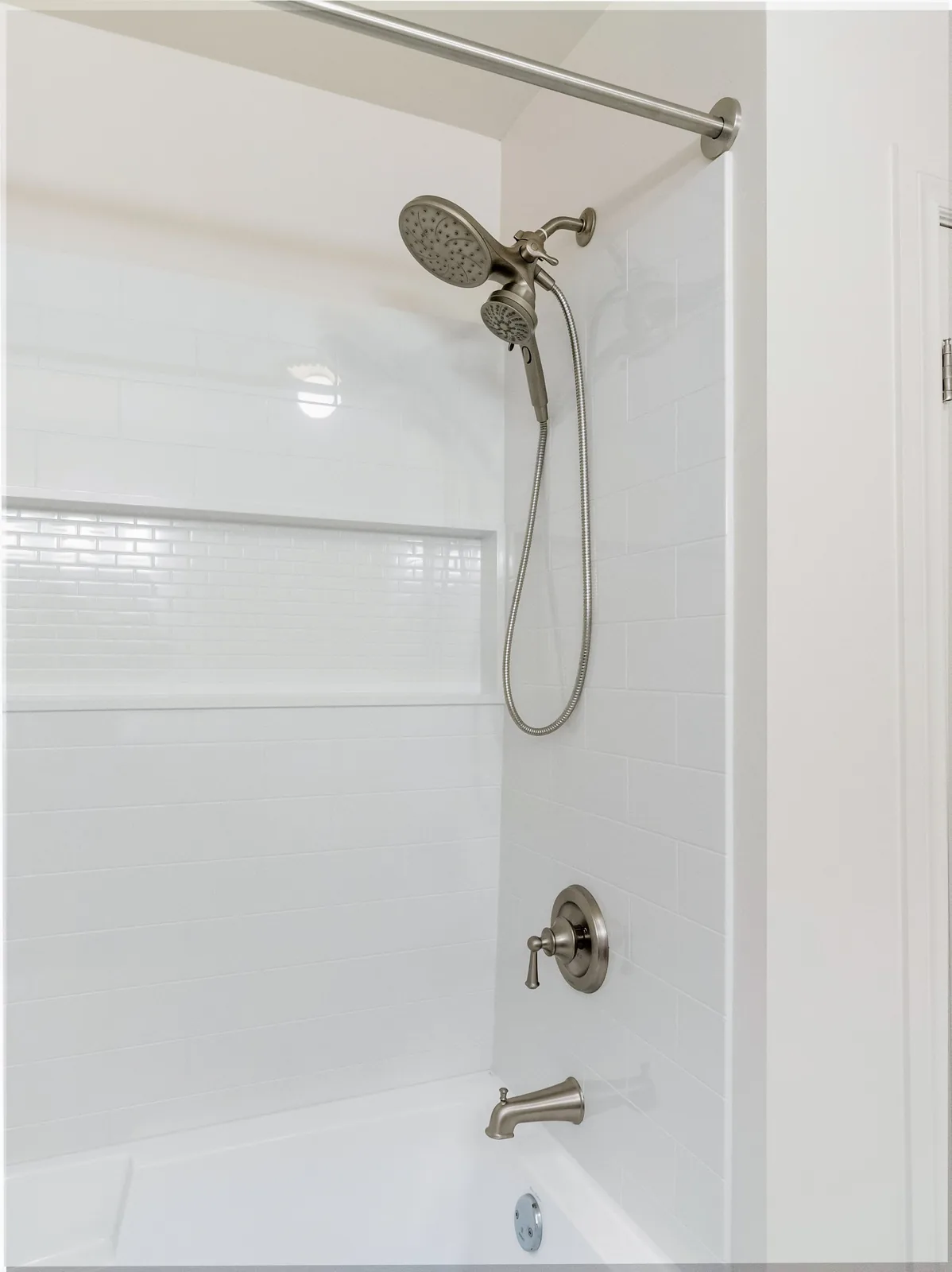 Shower head and grab rail set into the tub surround
