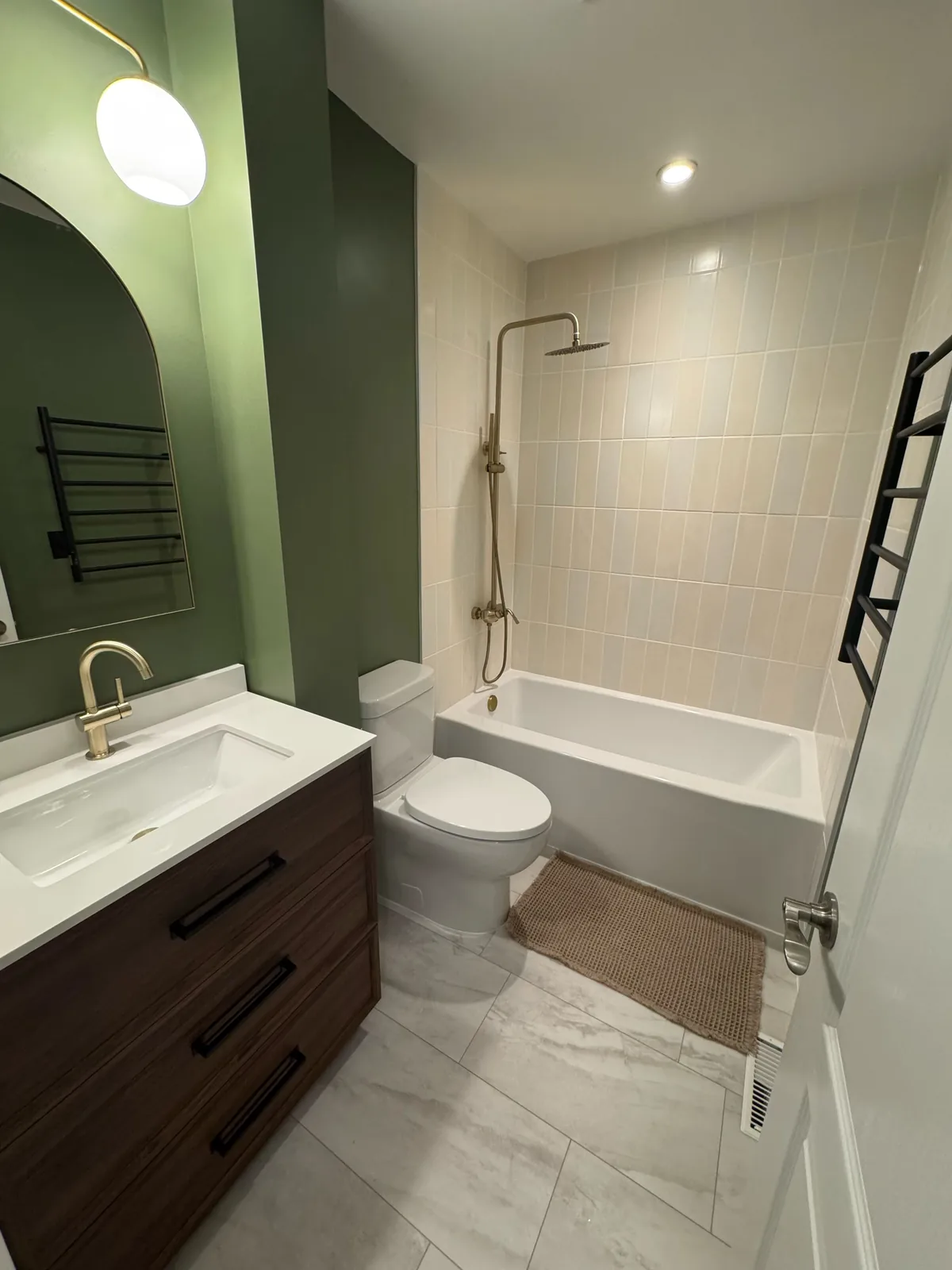 Walnut vanity and white top, brass tap under the arched mirror