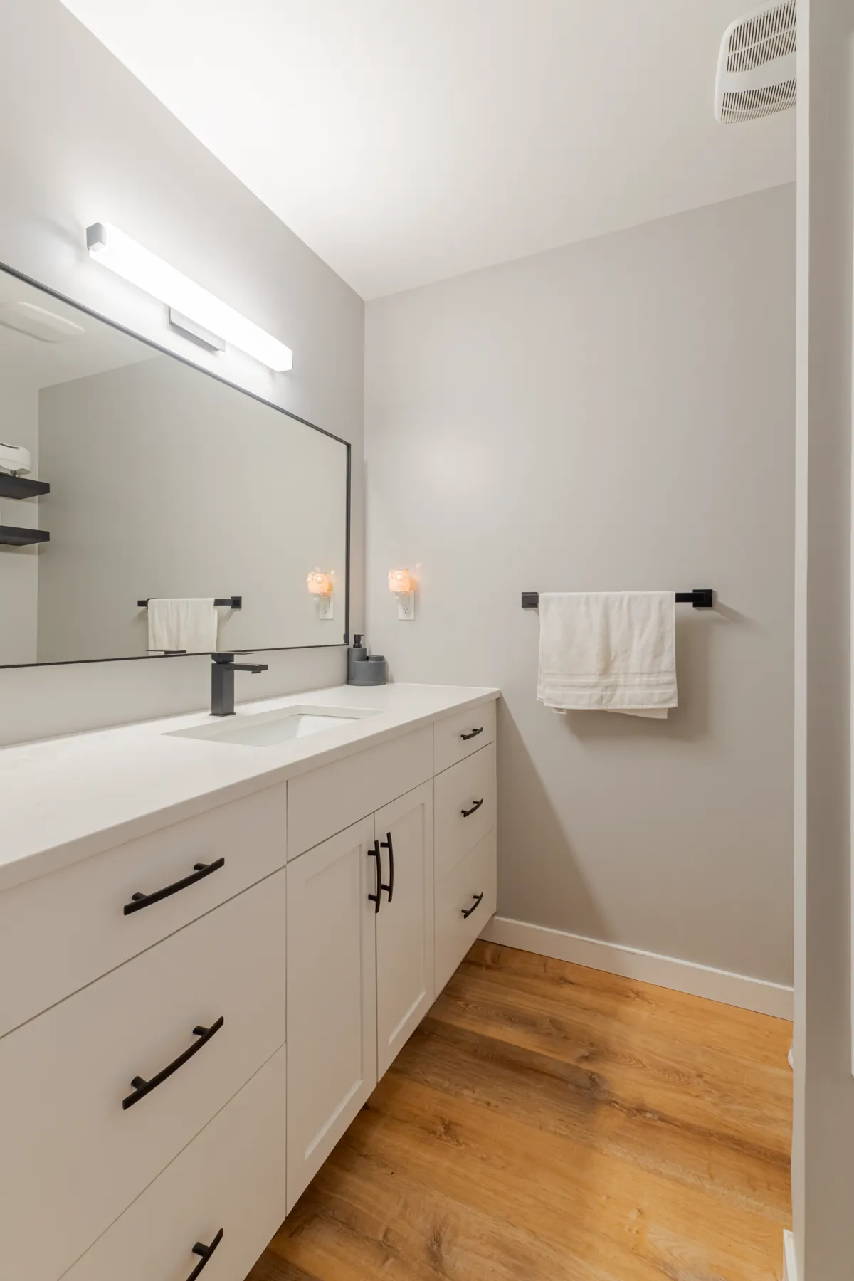 The bathroom vanity and its wide framed mirror