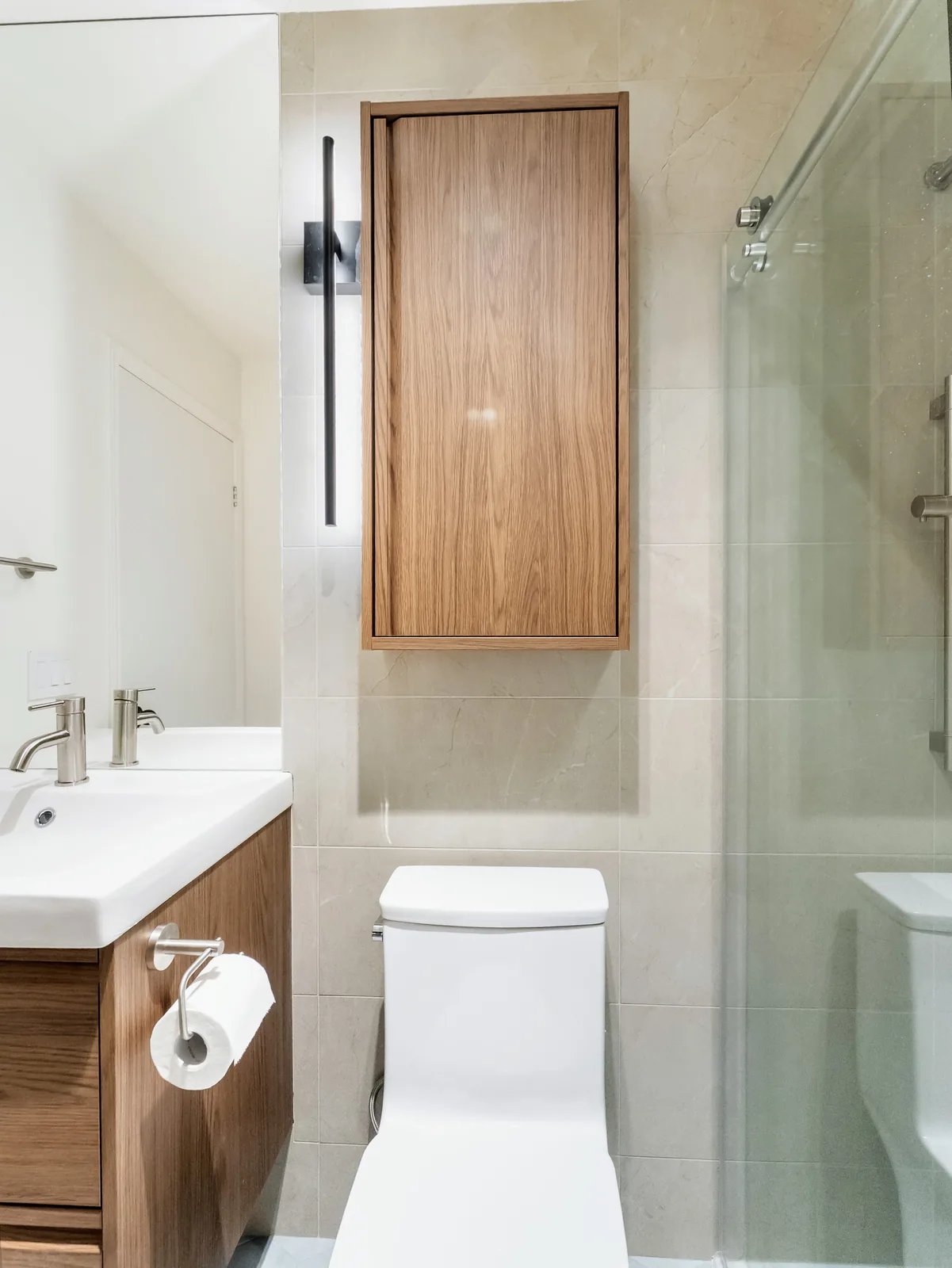 The room end to end: vanity, oak cabinet, toilet and the glazed shower