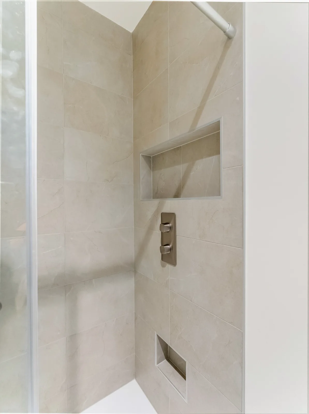 Shower niche and thermostatic controls set into the large-format tile