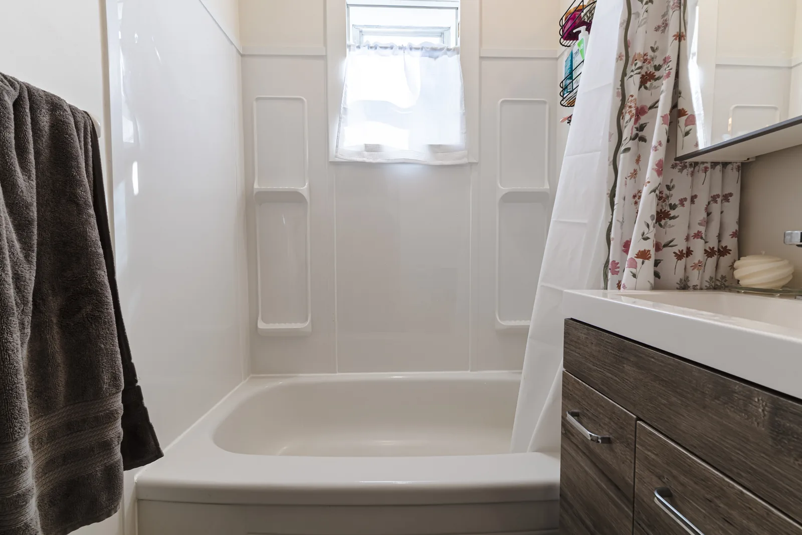 Tub and surround with the window above, vanity to the right