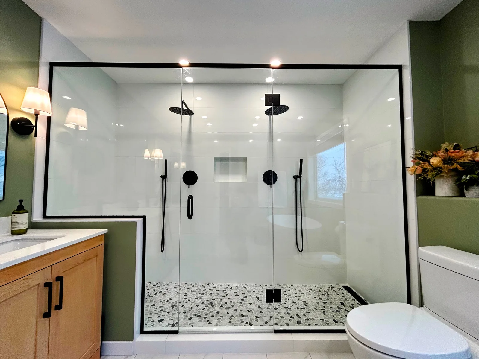The shower seen past the vanity, glass running the length of the room