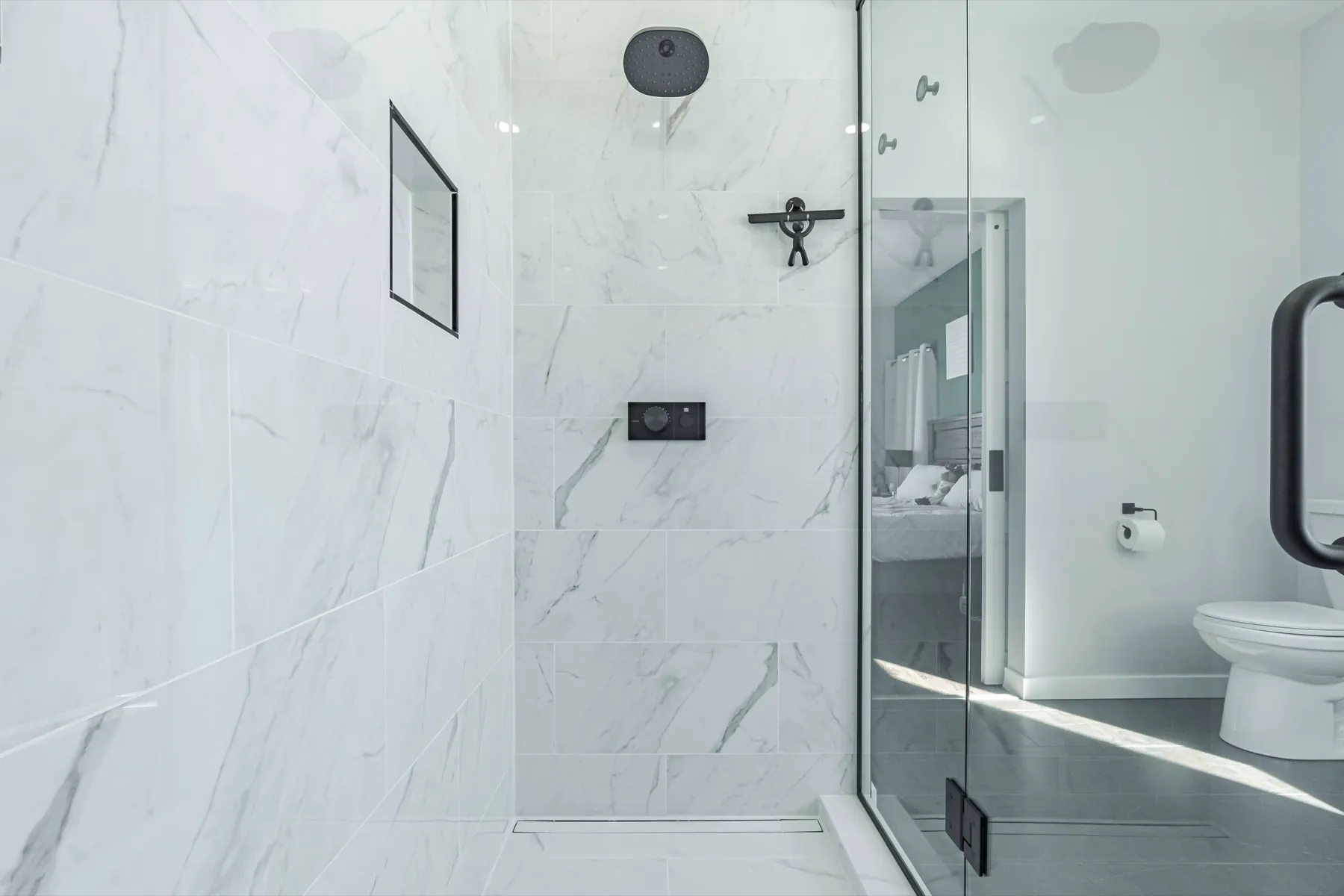 The shower wall and the toilet beyond it