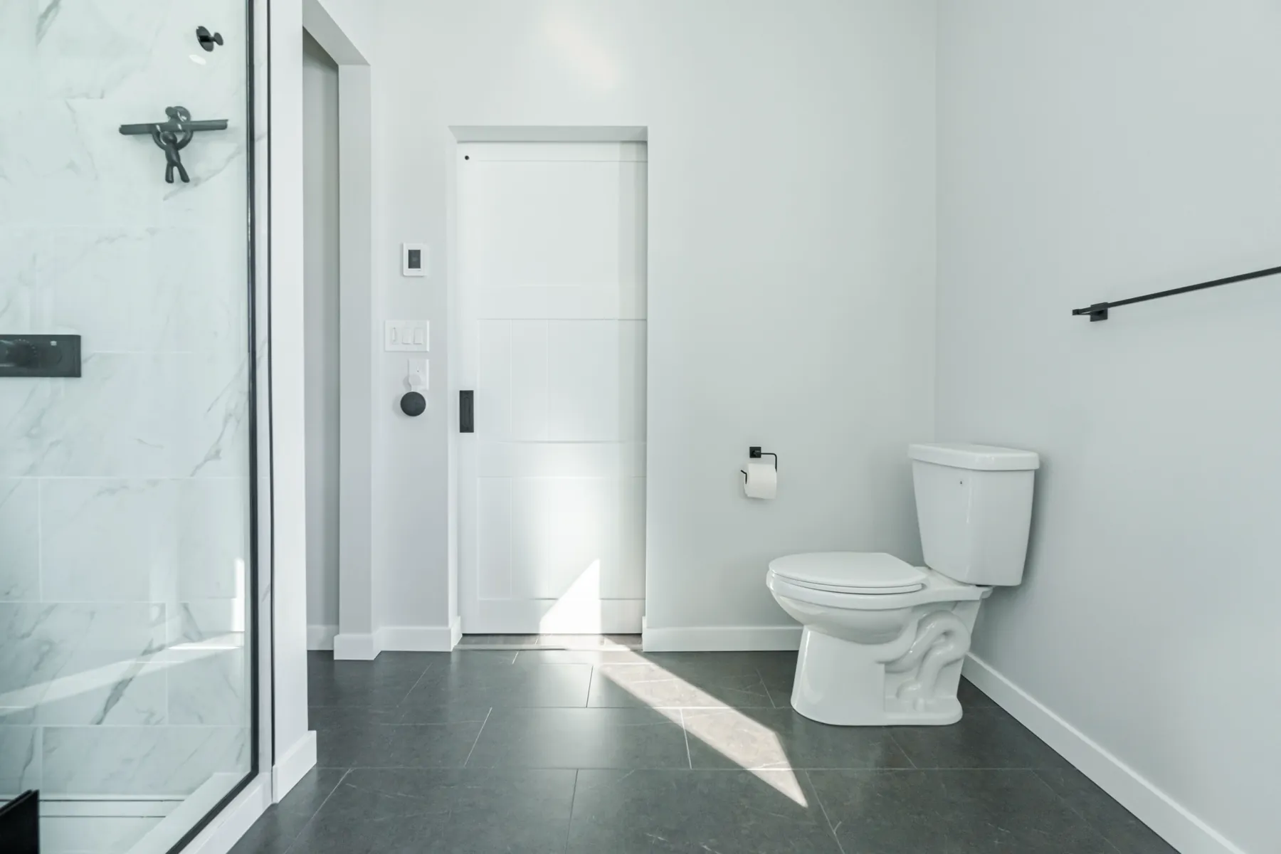 Large-format porcelain carried up to the ceiling beside the door