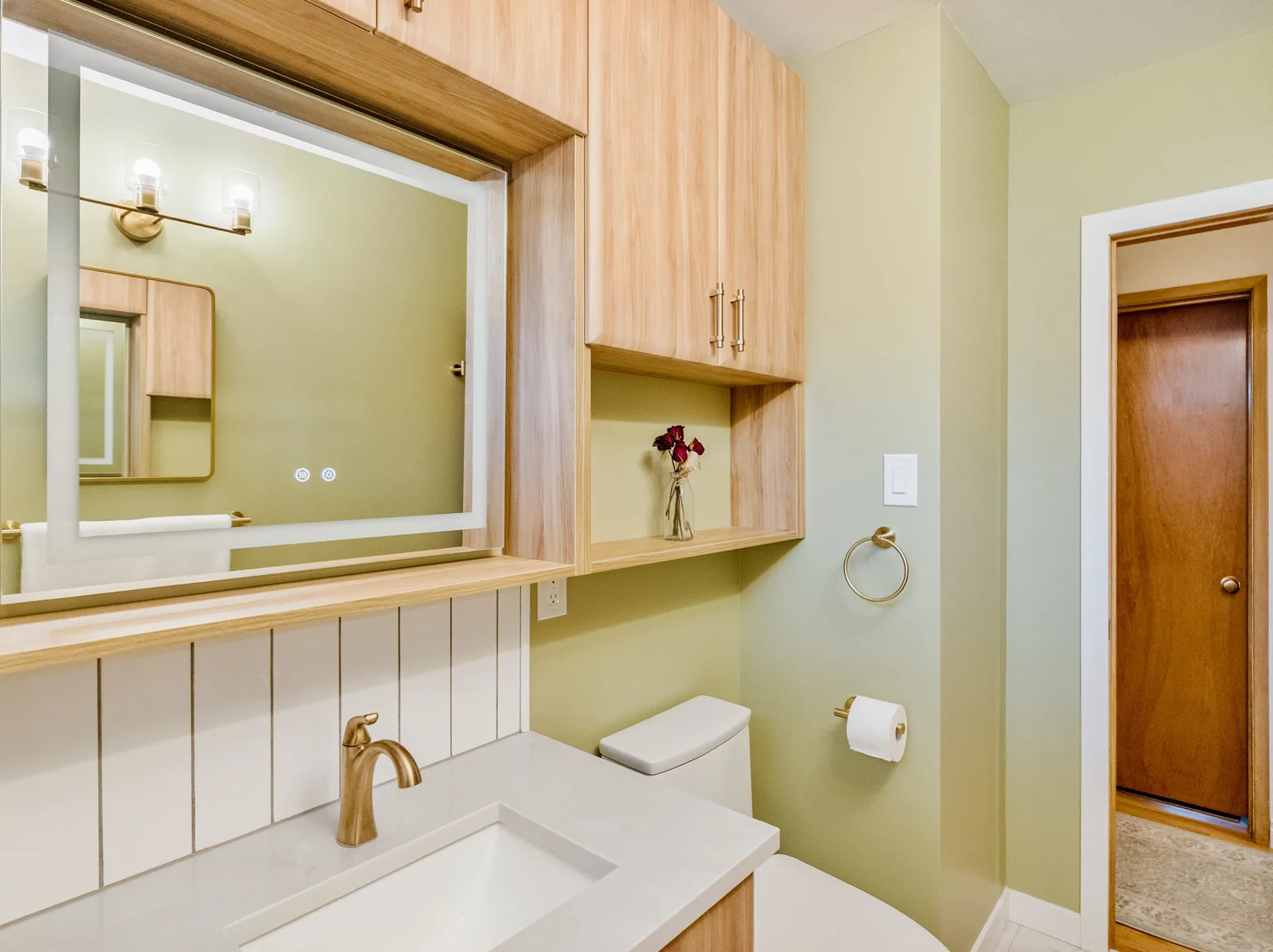Vanity run with the oak uppers, sage wall carrying through to the door