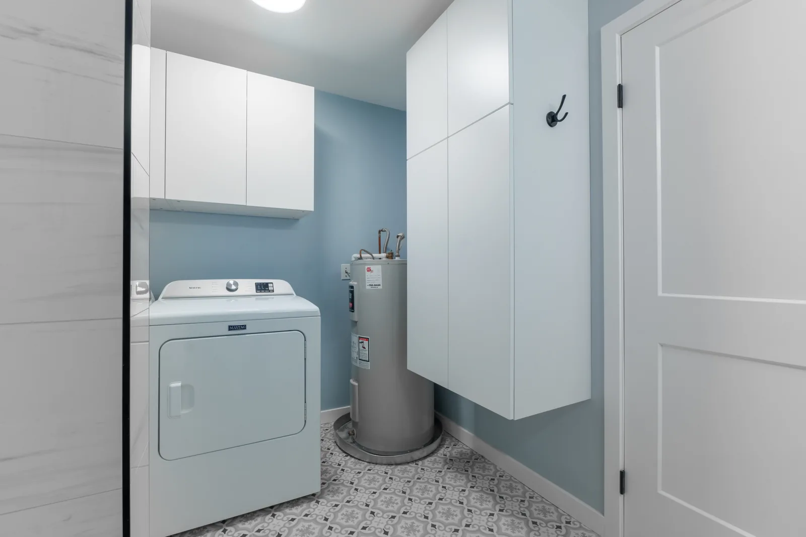 The laundry and utility corner, mosaic tile laid across the floor