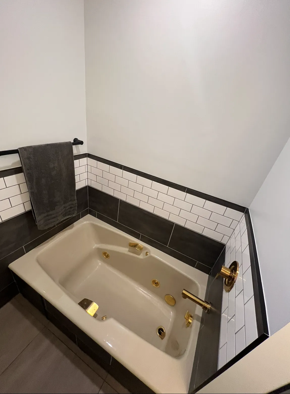 The tub in its subway surround, gold fittings against the black trim