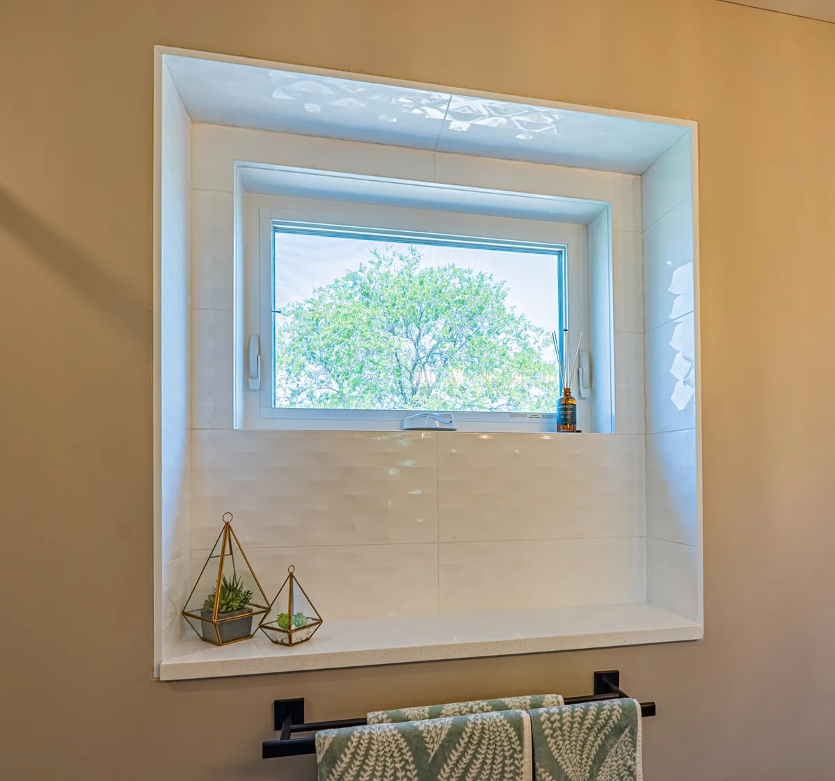 The ensuite window set in a tiled niche, a towel bar below