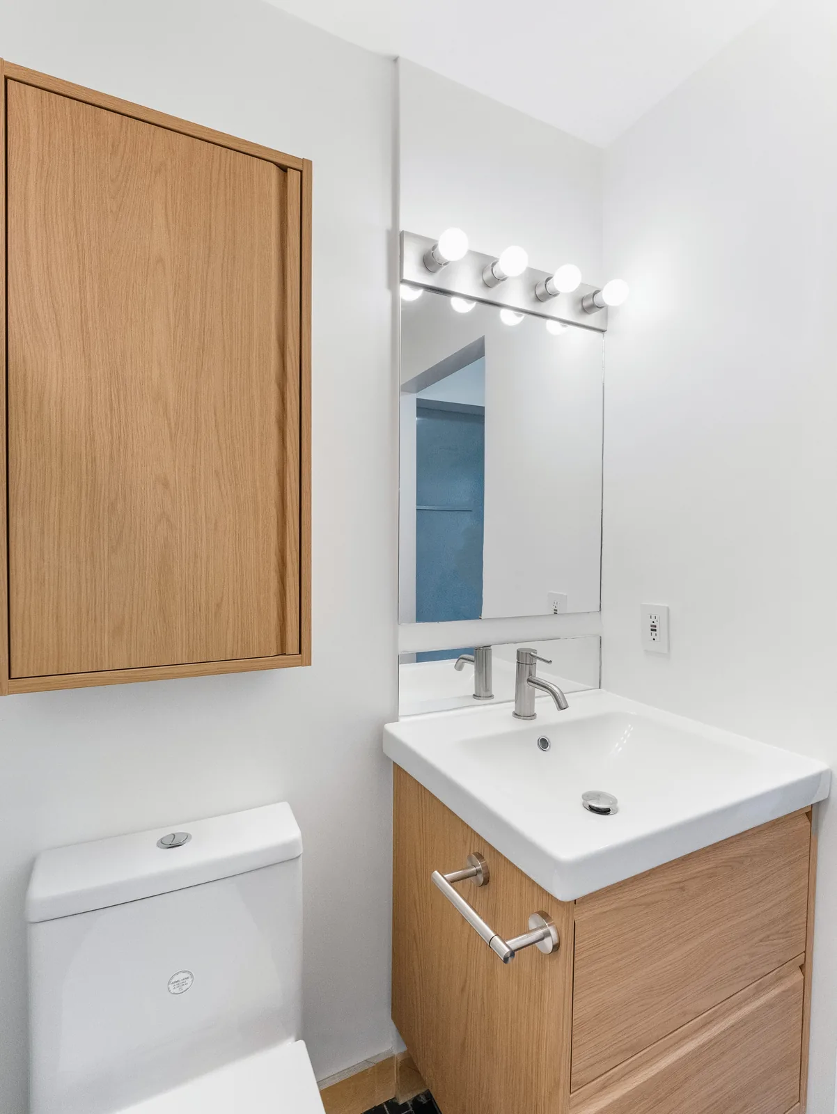Vanity, mirror and oak cabinet under the room's sloped ceiling