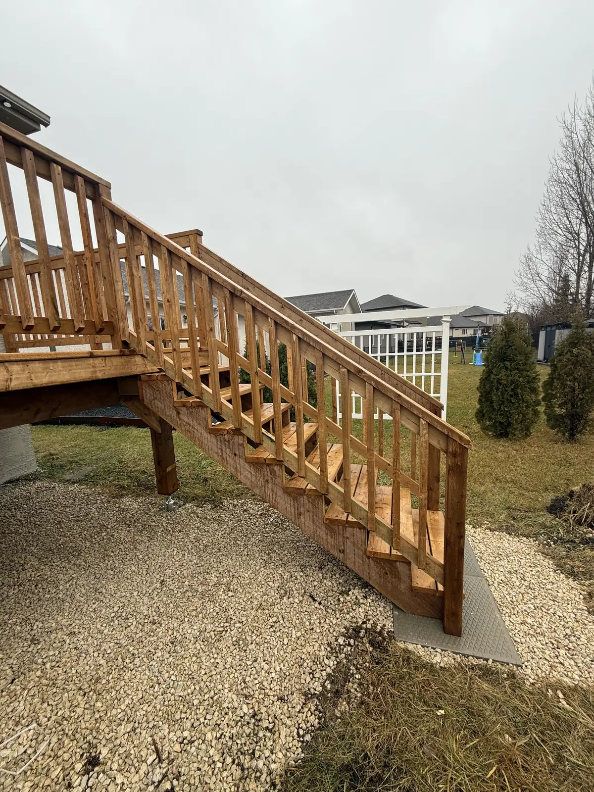 The cedar stair down from the deck, railed on both sides