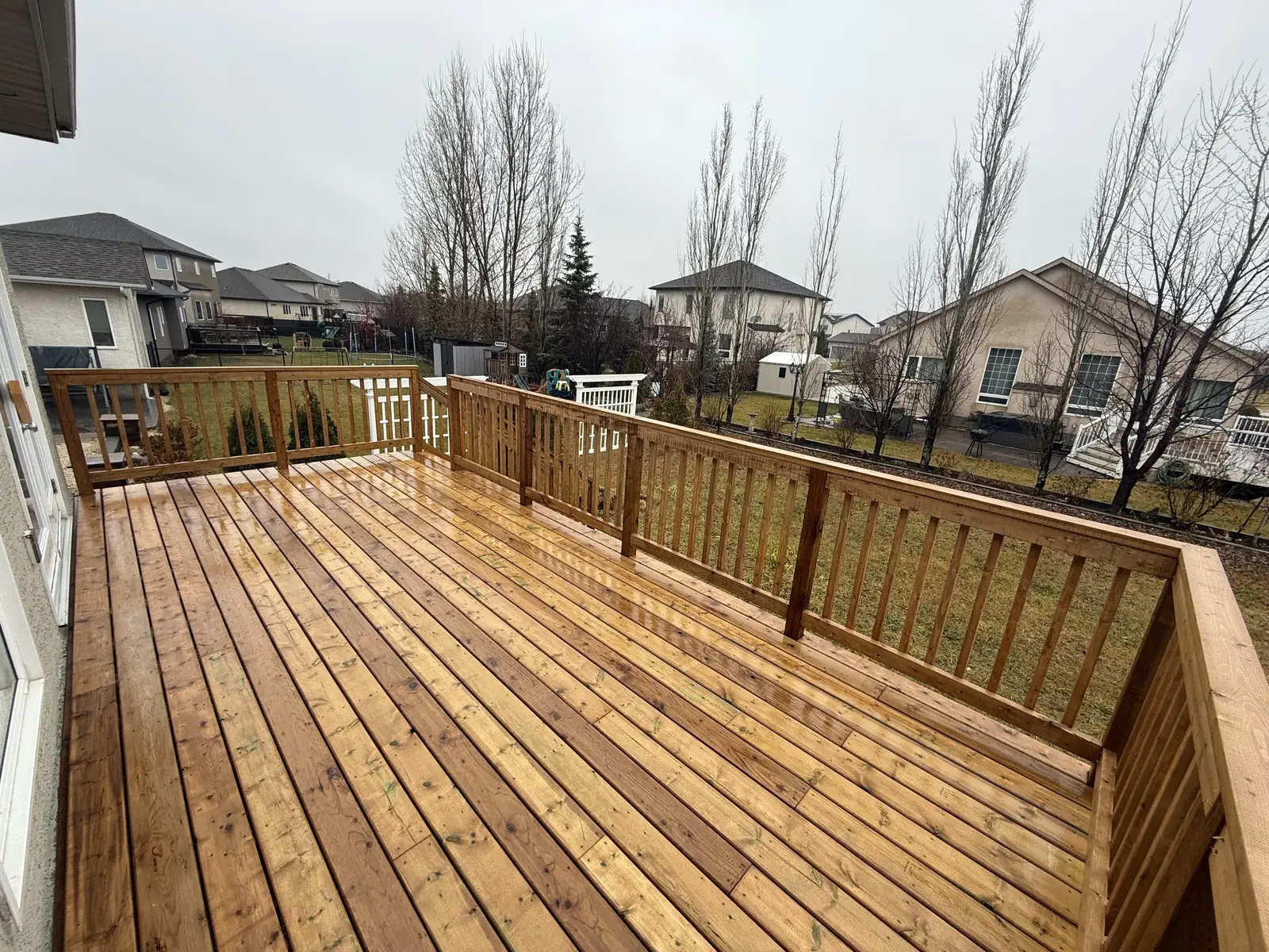 Rain on the new cedar boards, the railing running round to the yard