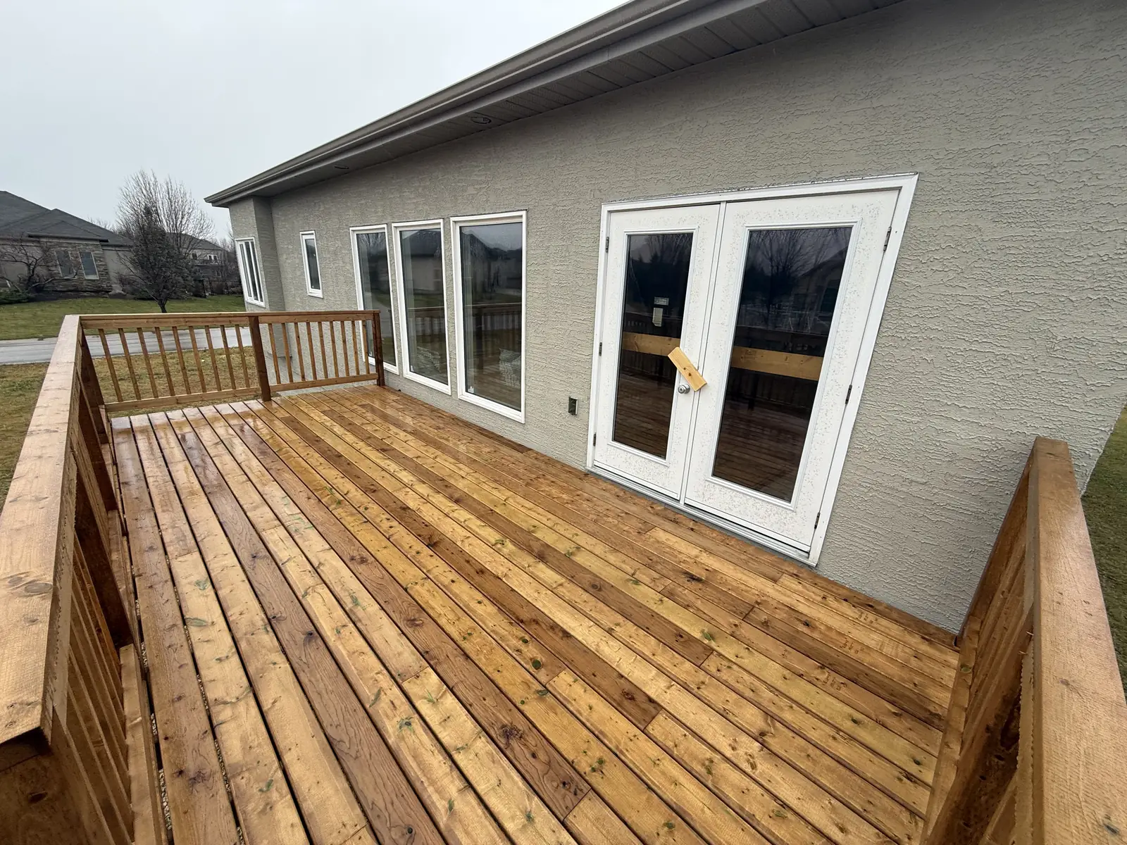 The deck outside the french doors, the boards still wet from the rain