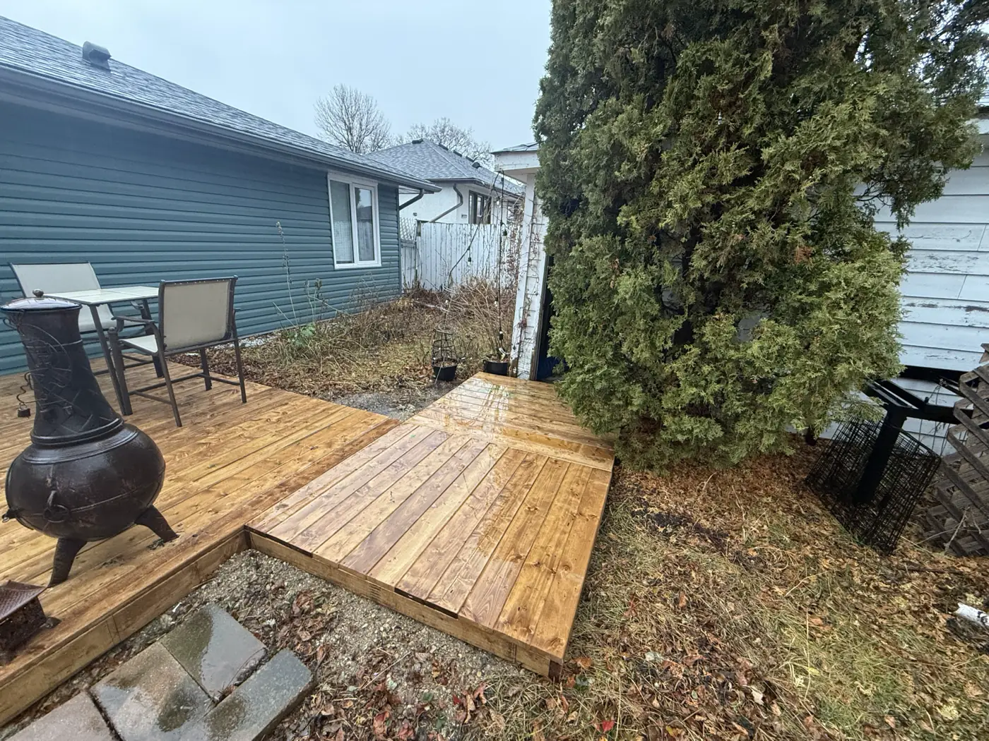 The deck from the yard, seating and chiminea set out on it