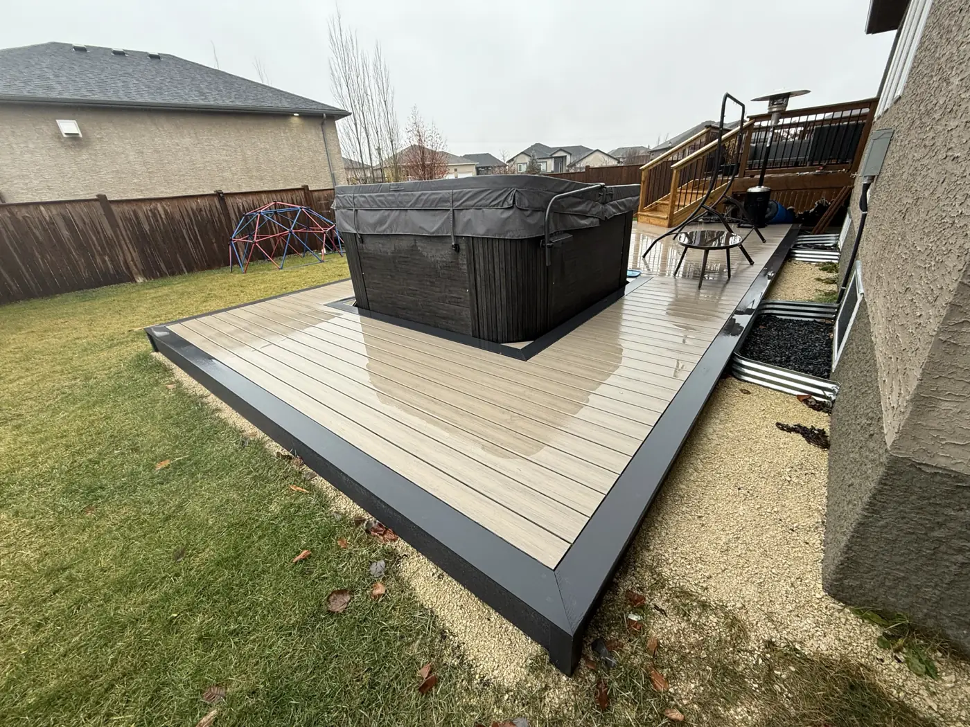 The composite deck and hot tub from the corner of the yard