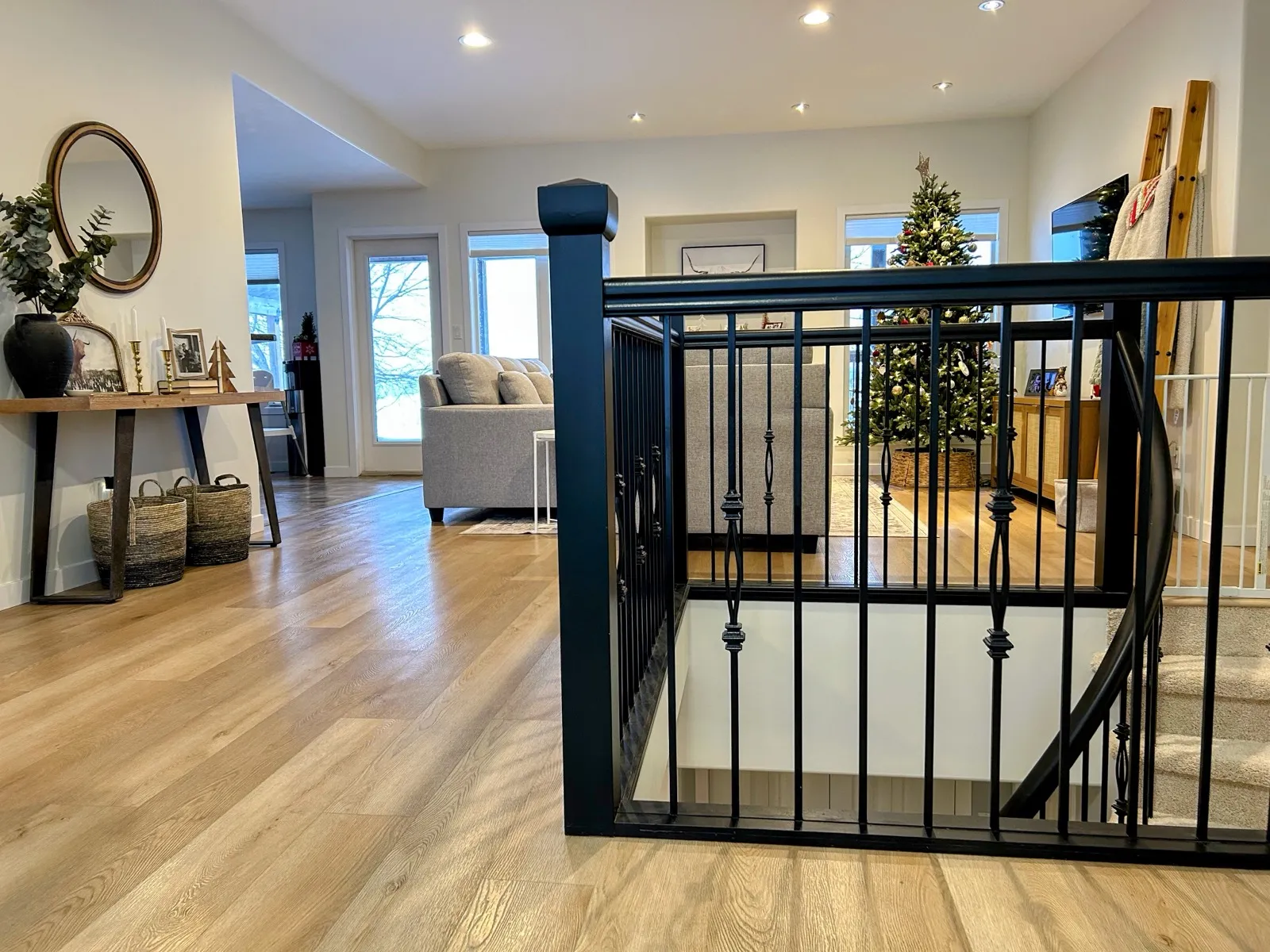 Black metal spindles and handrail around the open stairwell, plank floor running past