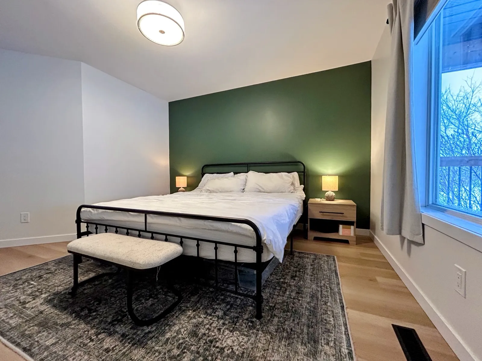 The primary bedroom, a green feature wall behind the bed