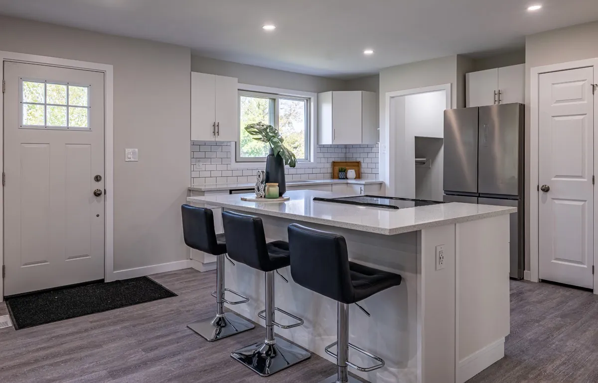The kitchen from the far side, island and range in one view