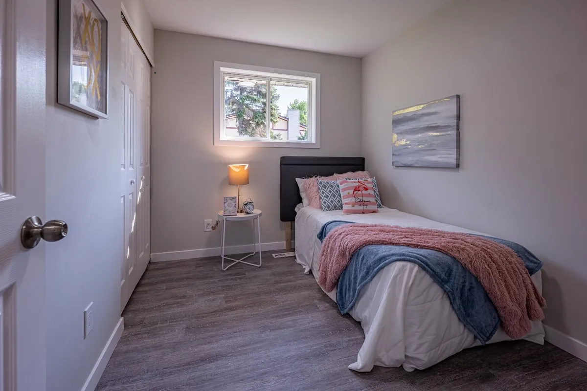 A second bedroom, staged and lit from the window
