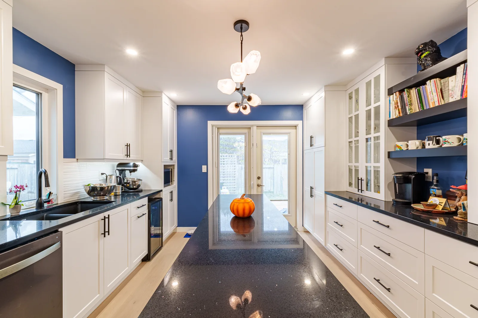 Looking through the kitchen to the garden doors, navy carried down the wall