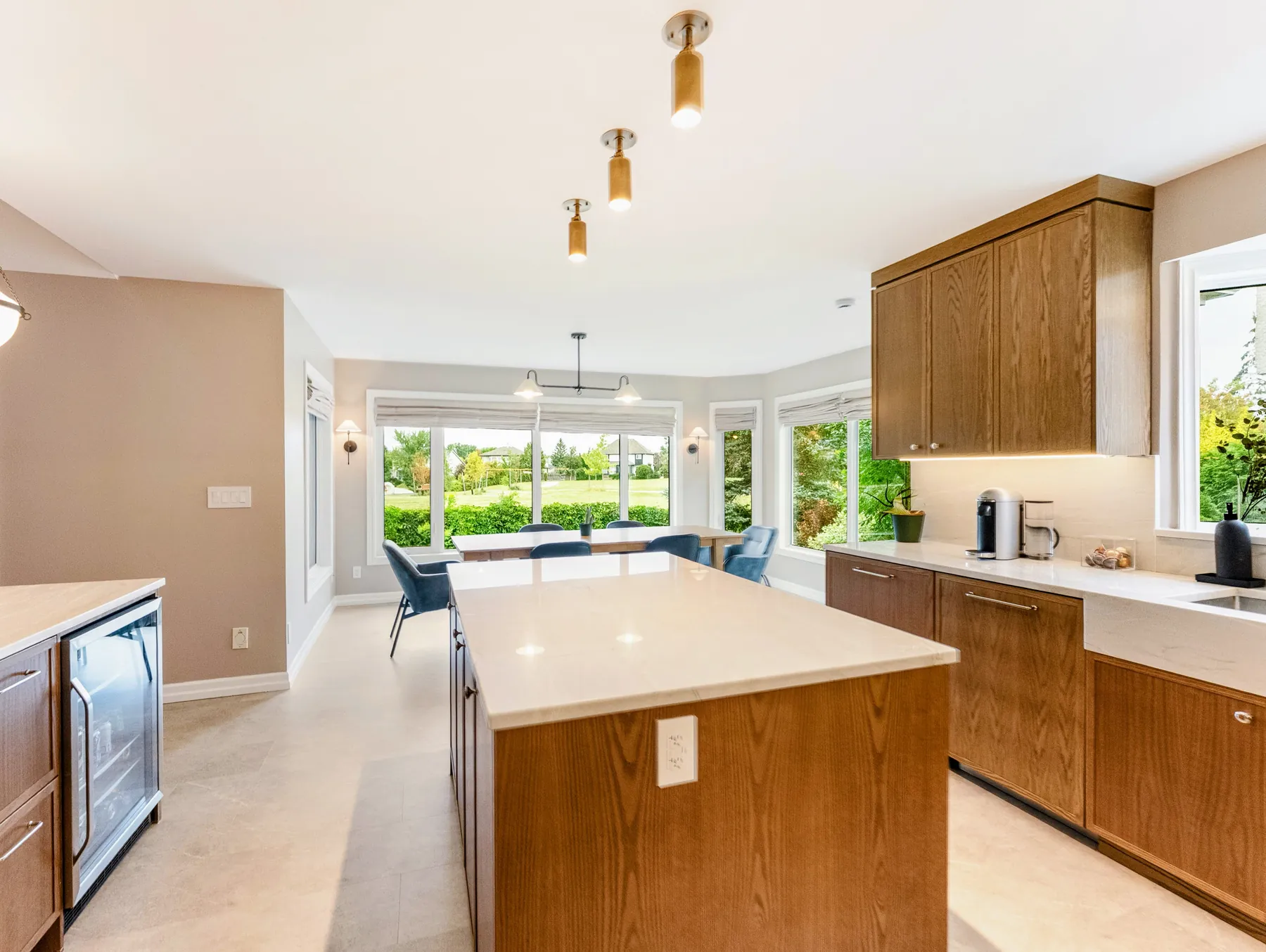 White-oak kitchen island, with the beverage fridge in the bar alongside and the dining bay beyond