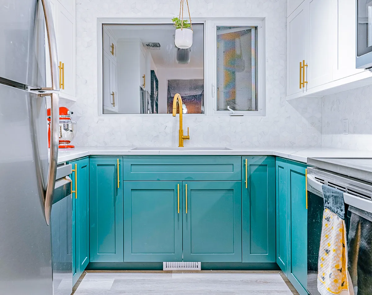 The teal run with a brass tap and marble backsplash under the window