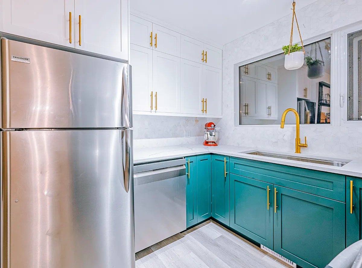 Fridge and white upper cabinetry above the teal bases
