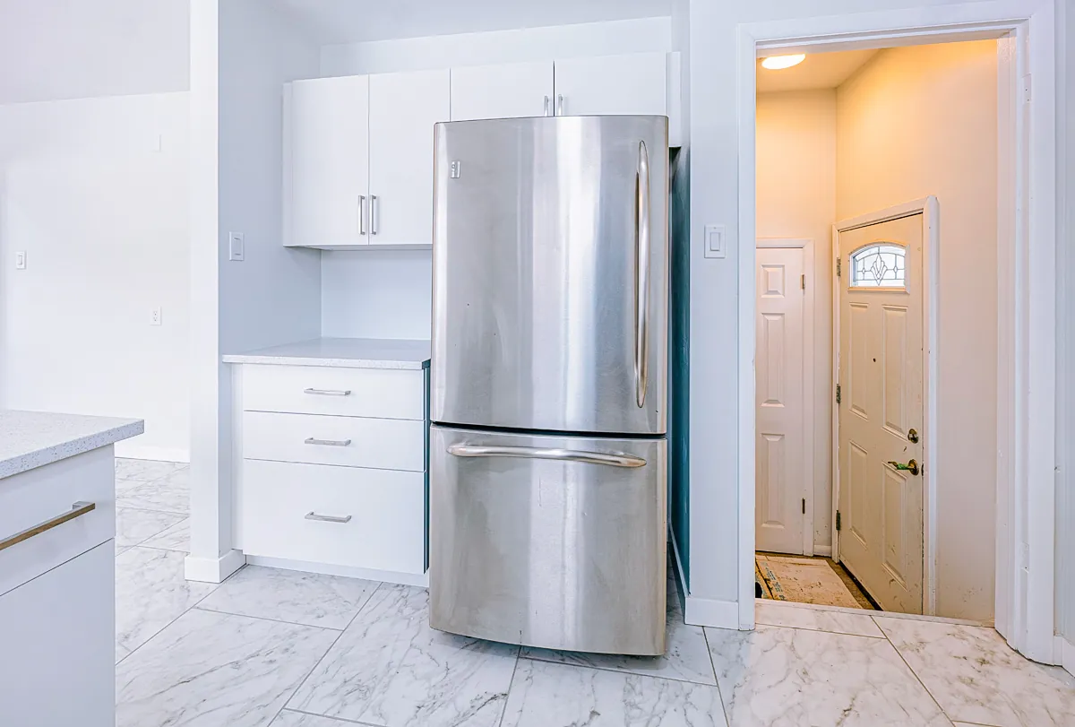 Fridge and cabinetry beside the entry door