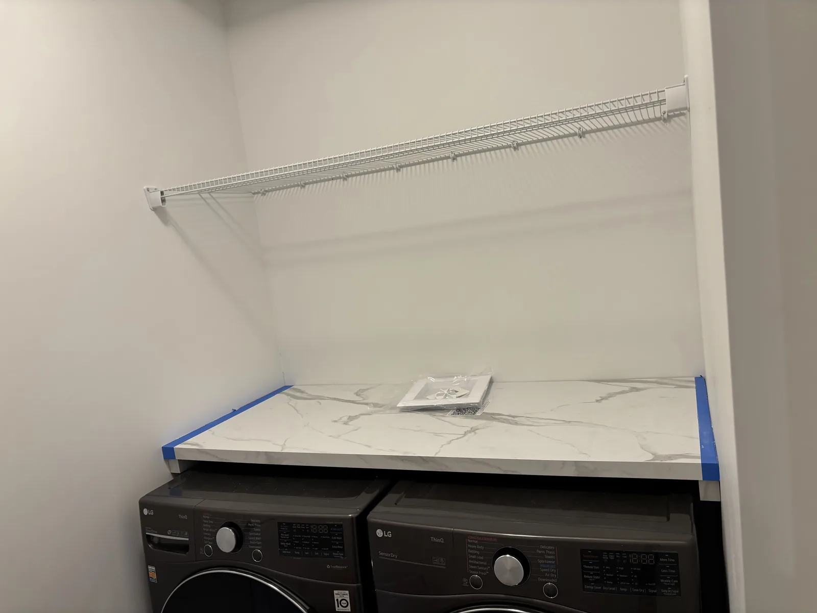 Marble-veined counter run laid over the washer and dryer