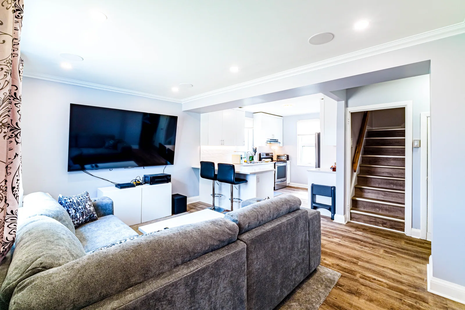 Open living area with the stair beyond, plank flooring carried through