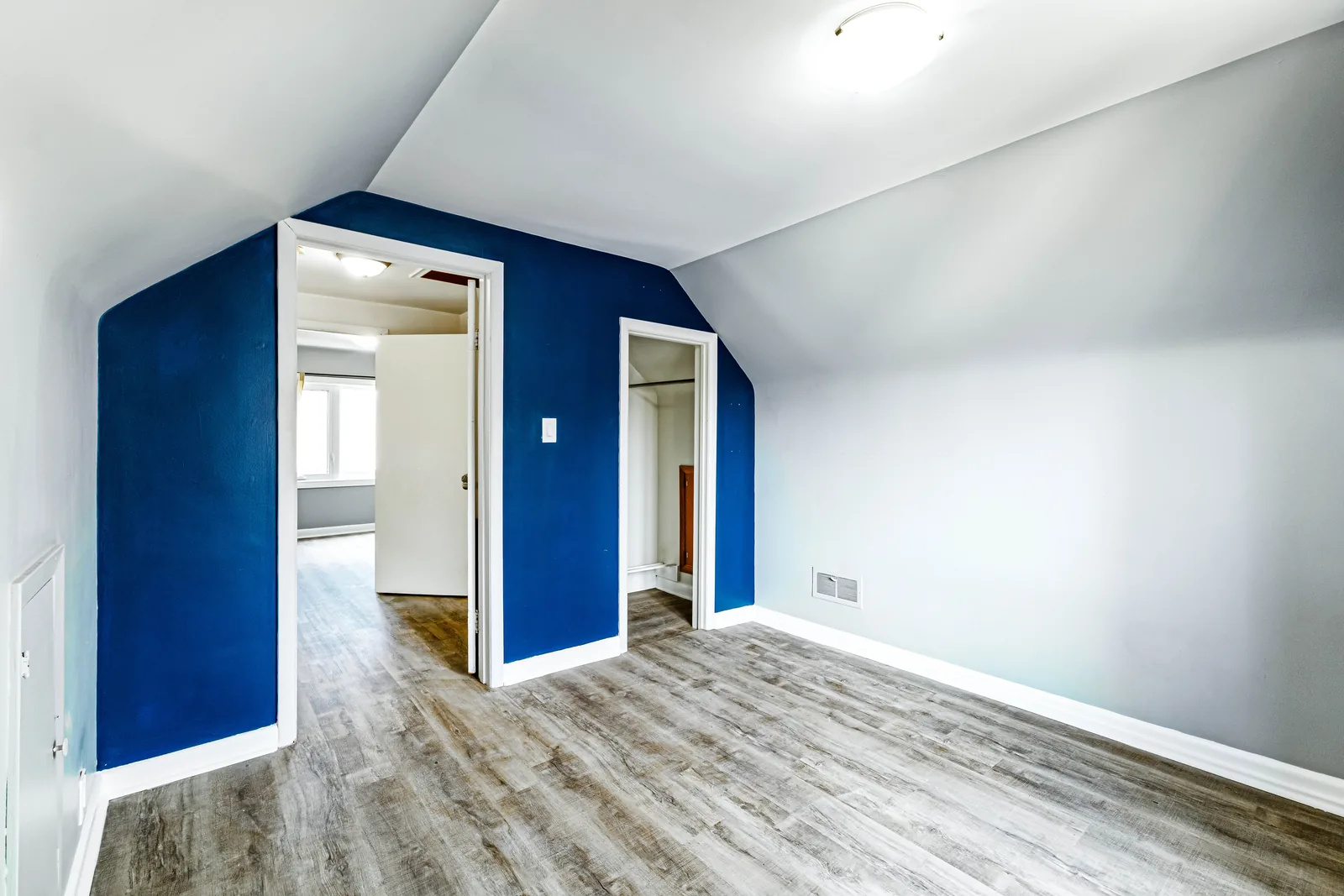Bedroom with a navy accent wall against pale grey
