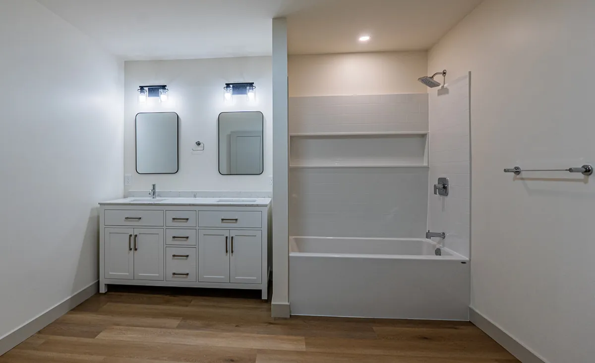 Ensuite with a double vanity, framed mirrors and a tub-shower