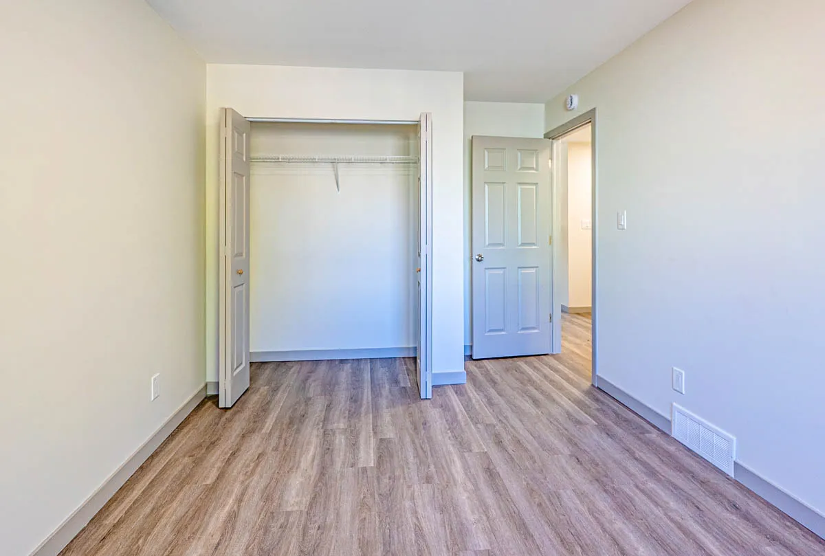 Bedroom closet and door, the plank floor running through