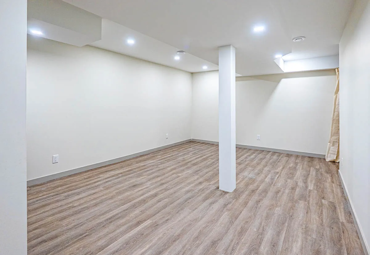 The finished basement, open and pot-lit, vinyl plank throughout