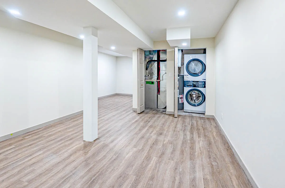 The basement, a stacked washer and dryer in the utility room