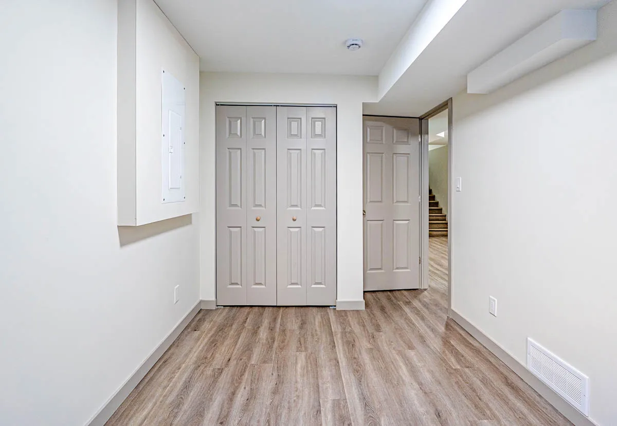 Basement room with double closet doors and a doorway through