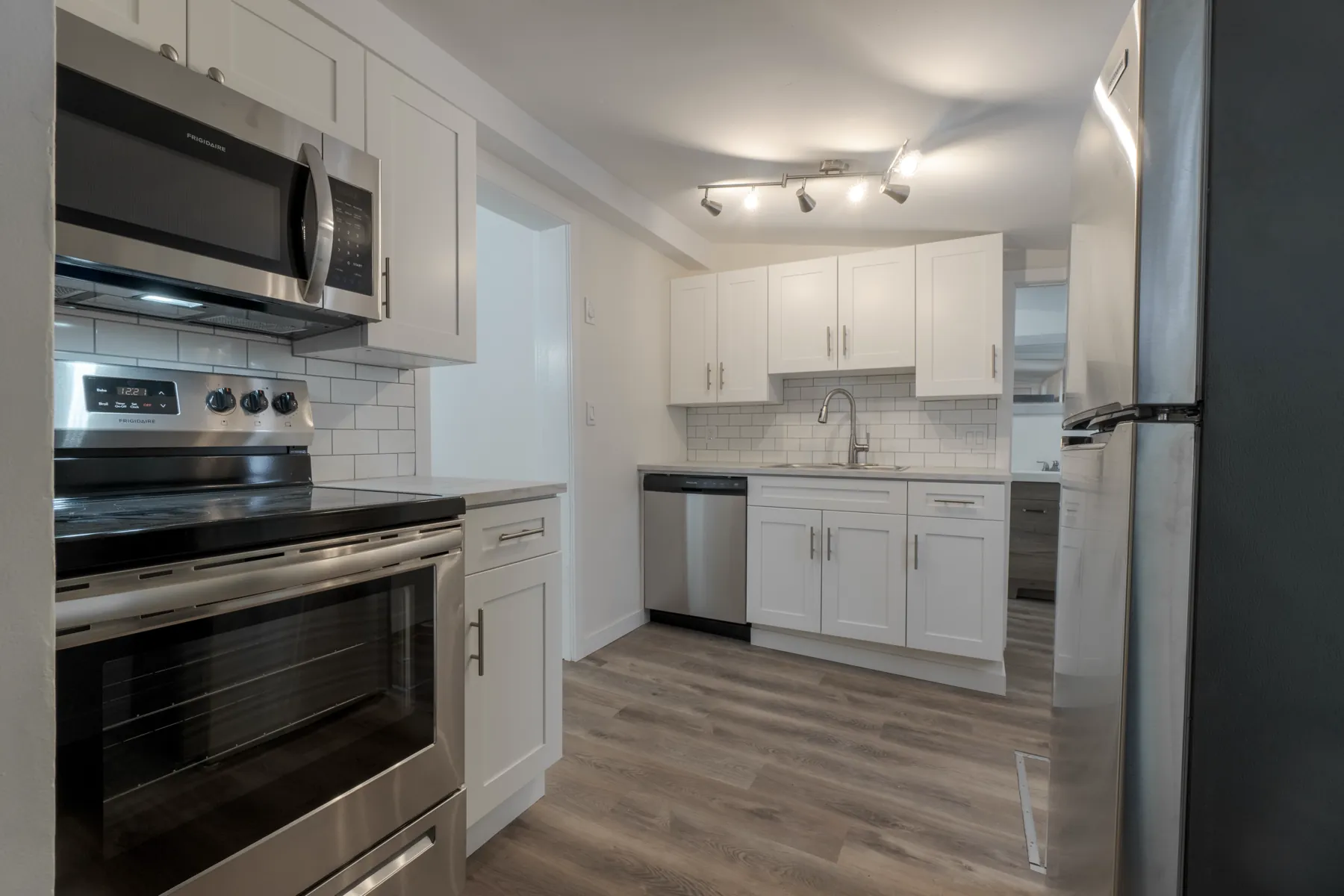 The kitchen run with its range, microwave and subway backsplash
