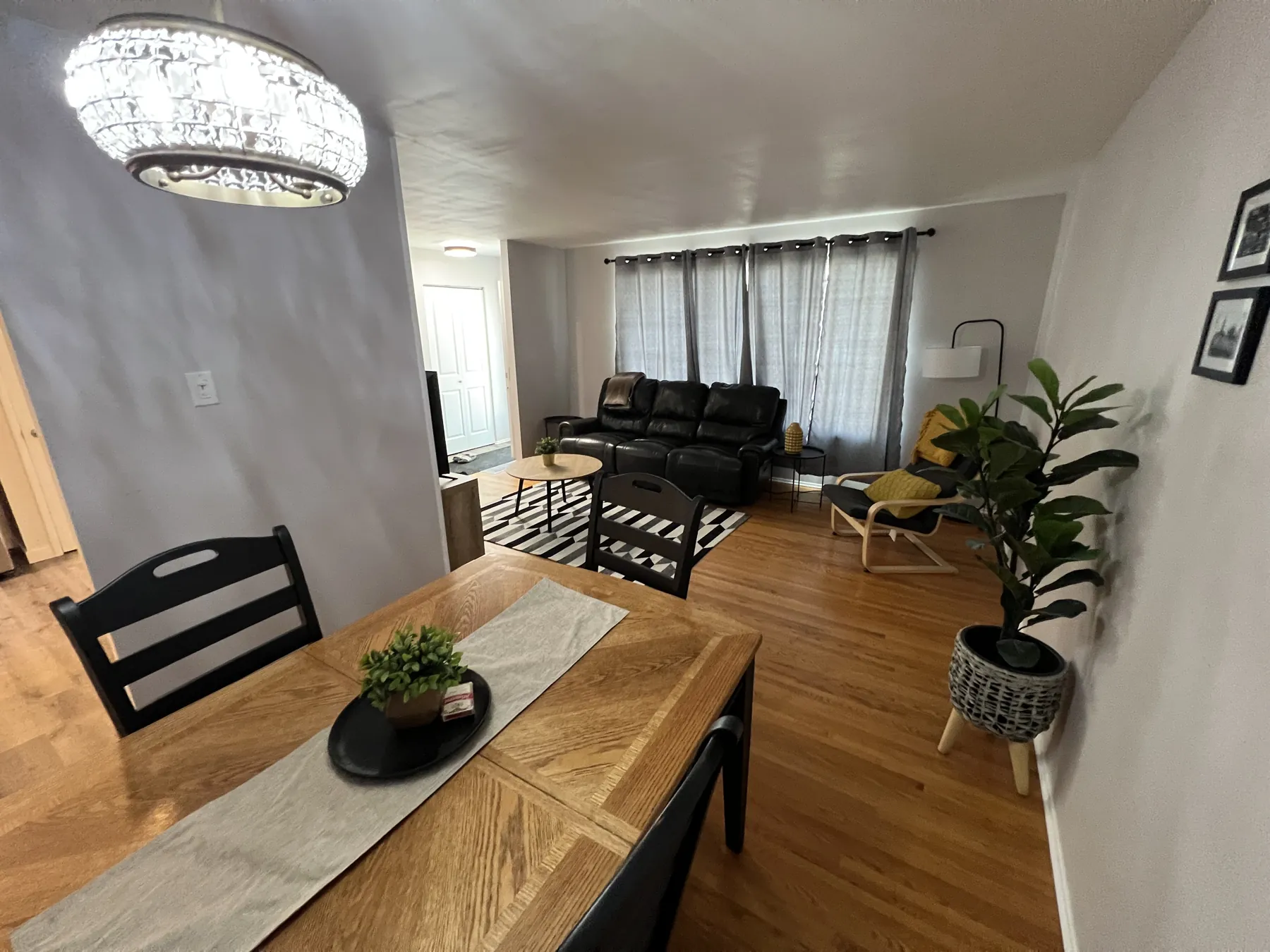 Open living and dining space under a drum pendant