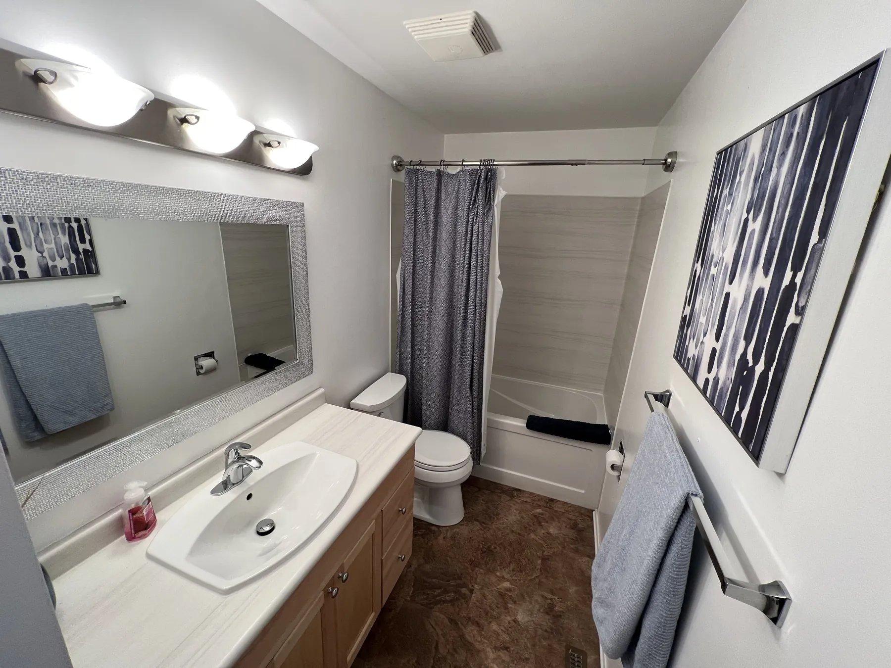 Bathroom vanity under a wide mirror