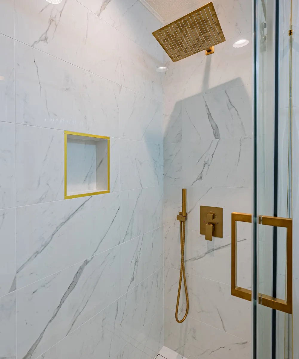 Third bathroom shower, a gold niche and rain head behind glass