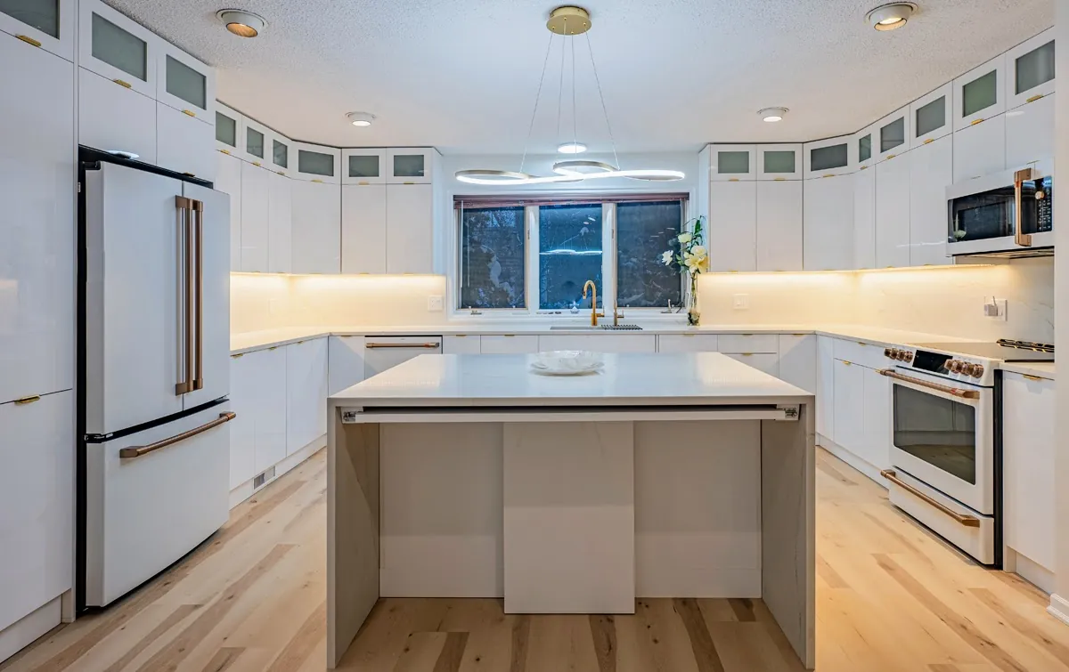 The island and fridge wall, glass-front uppers running round the room