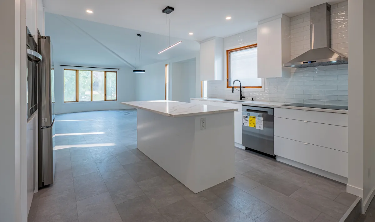 The kitchen in full, range and hood set between the uppers