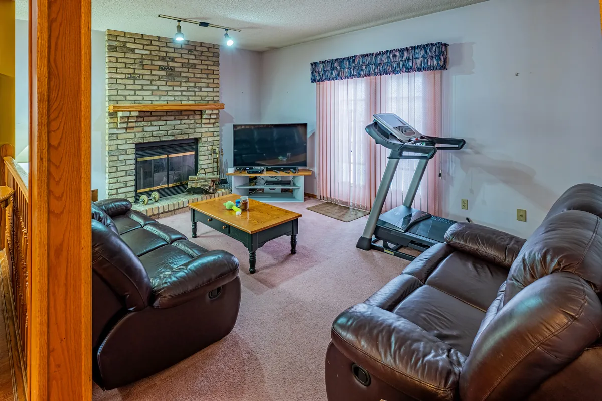 Before: the family room with a brick fireplace and carpet