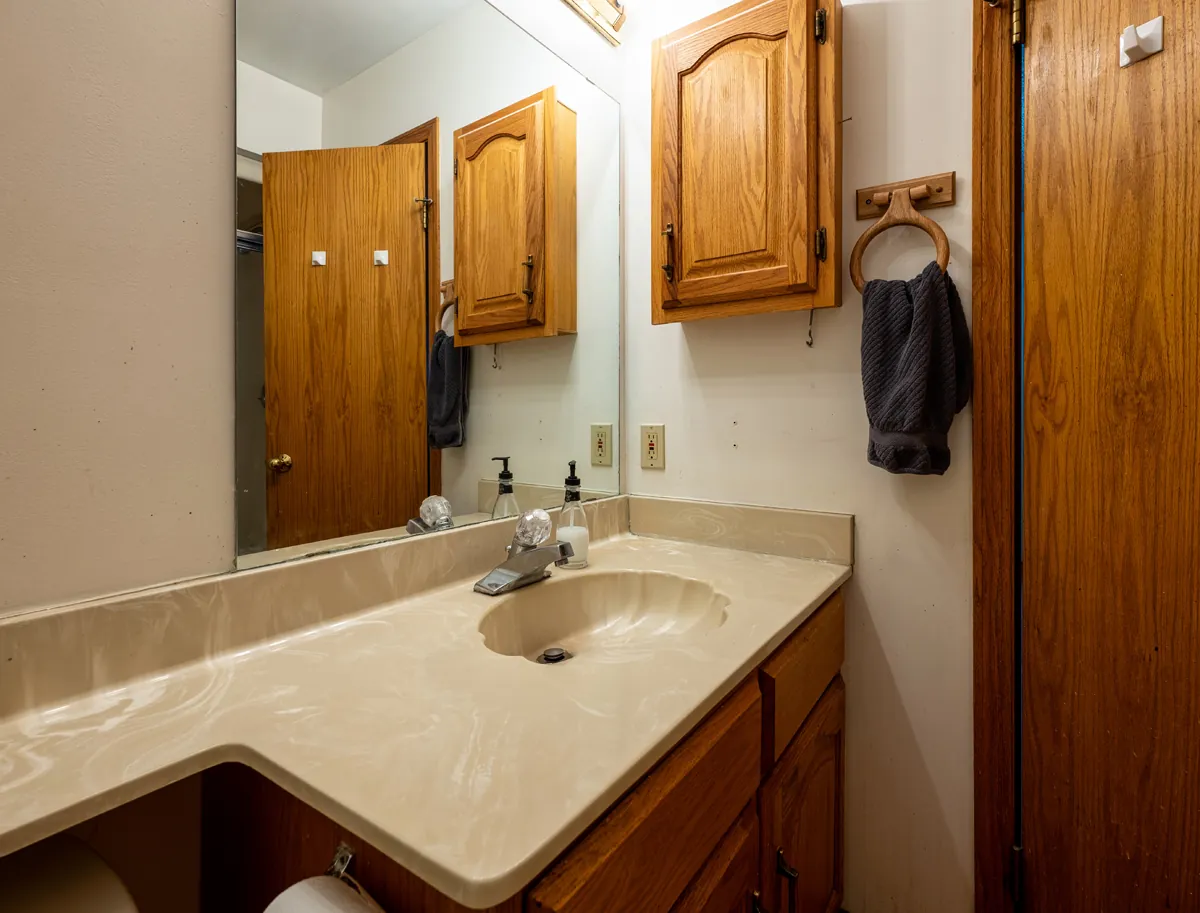 Before: the second bathroom's oak vanity and mirror