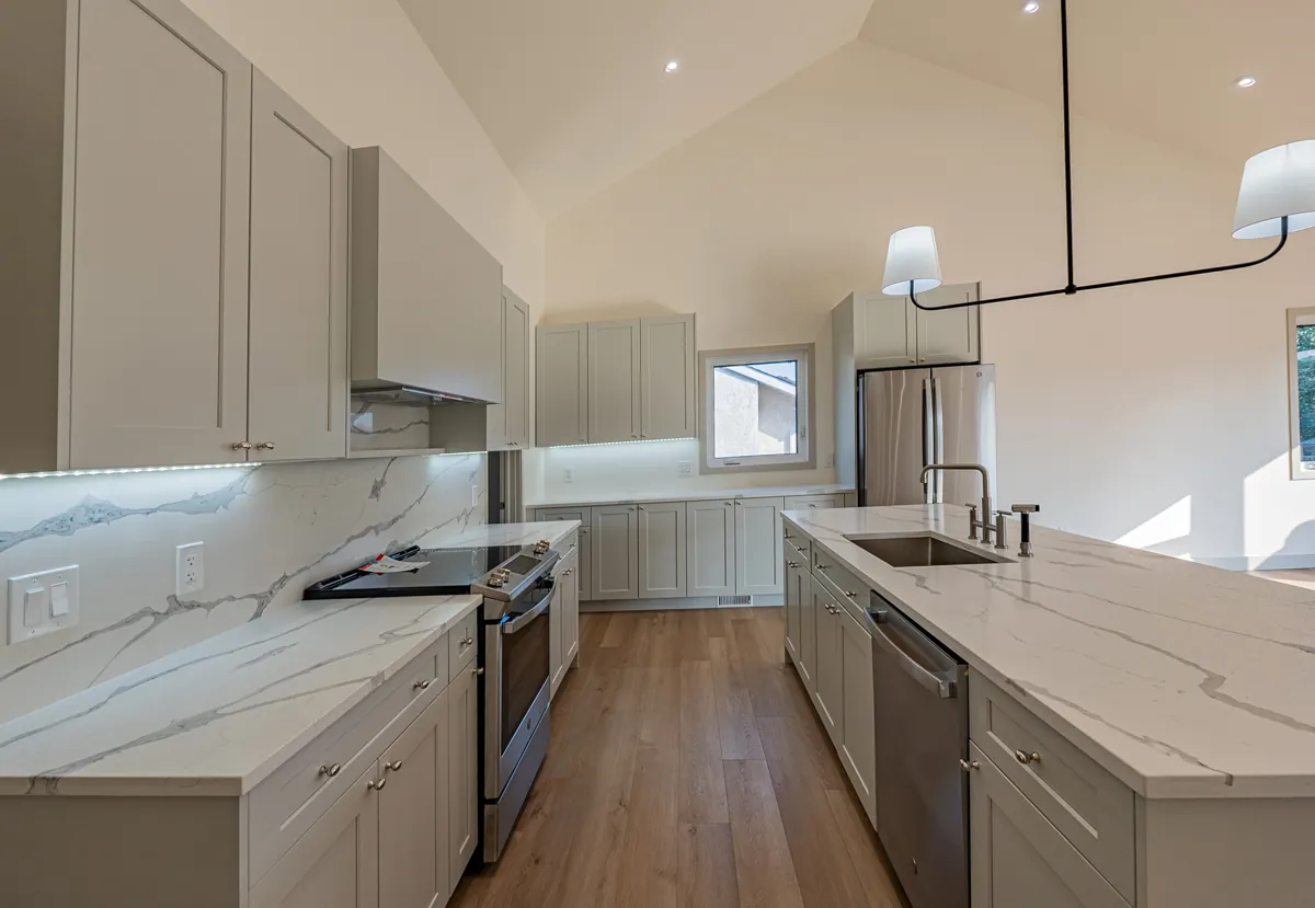 Kitchen with marble backsplash and quartz island